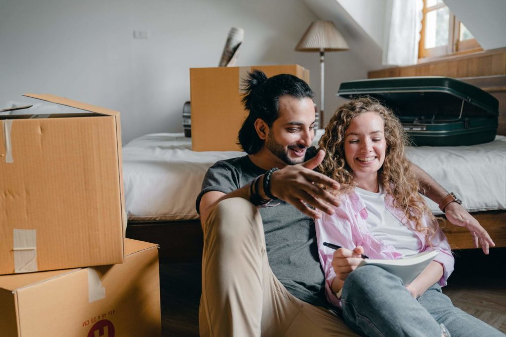 a man and a woman sitting on a bed