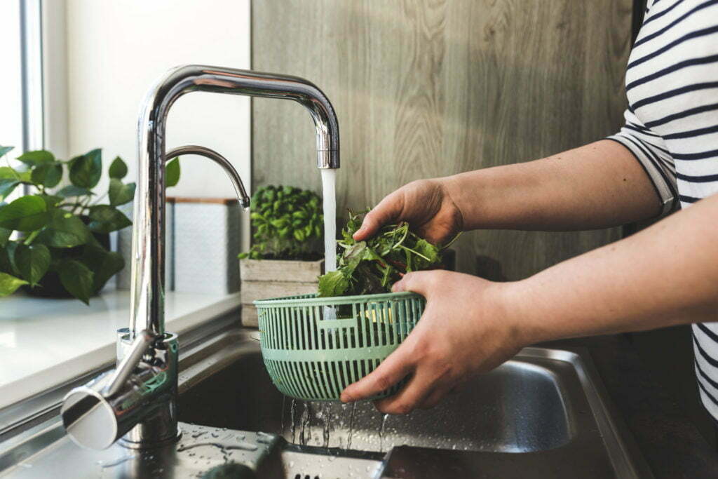 a person putting broccoli in a pot